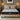 Front view of SpringFit Memory Foam Premium Mattress on a beige platform bed in a moody bedroom with warm Edison bulb pendant lighting and dark nightstand